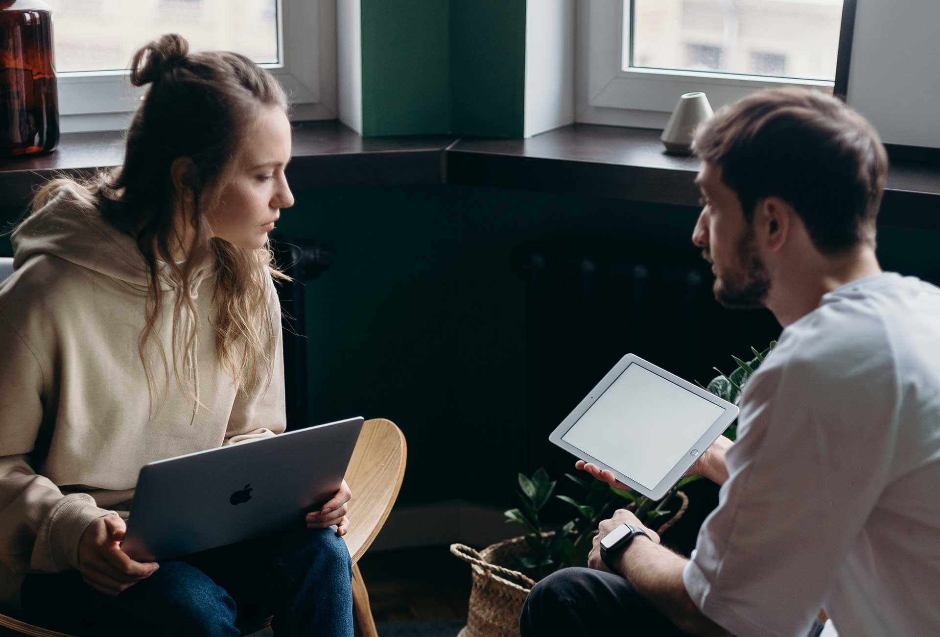 Man showing woman something on a tablet
